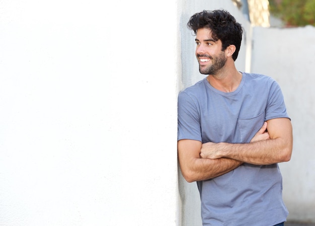 Confident handsome man standing with arms crossed outside