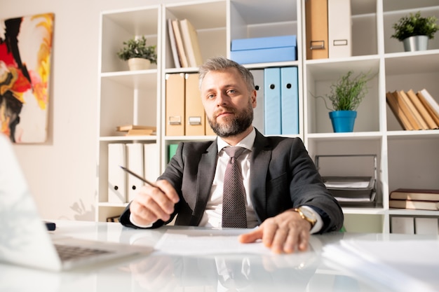 Confident handsome manager in modern office