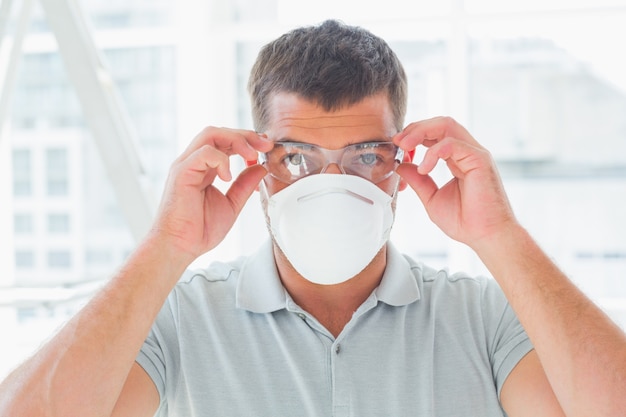 Photo confident handyman wearing protective eyewear and mask