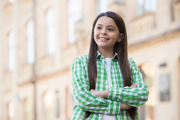 Confident happy girl with long hair in casual style keep arms crossed urban outdoors, confidence.