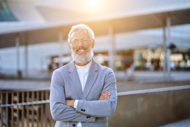 Confident happy mature older business man standing outdoors portrait