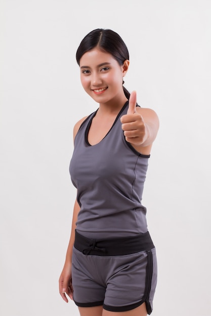 Confident happy smiling fitness woman giving thumb up