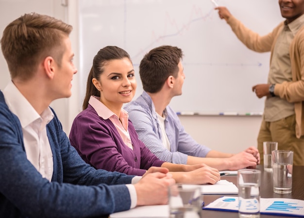 Confident international businessman in meeting at office with team