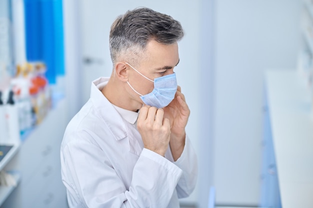 Confident in lab coat and protective mask