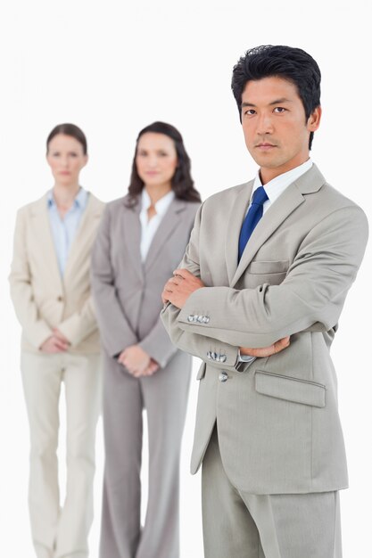 Confident looking businessman with his team behind him