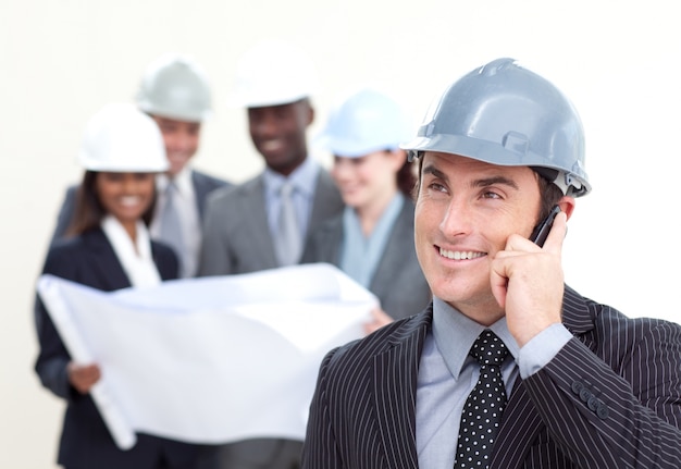 Confident male architect with his team in the background