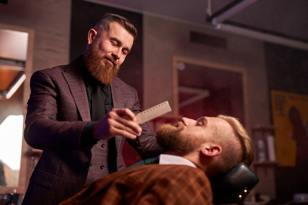 Confident male barber his client in the salon