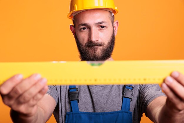 Confident male carpenter looking at construction leveler person