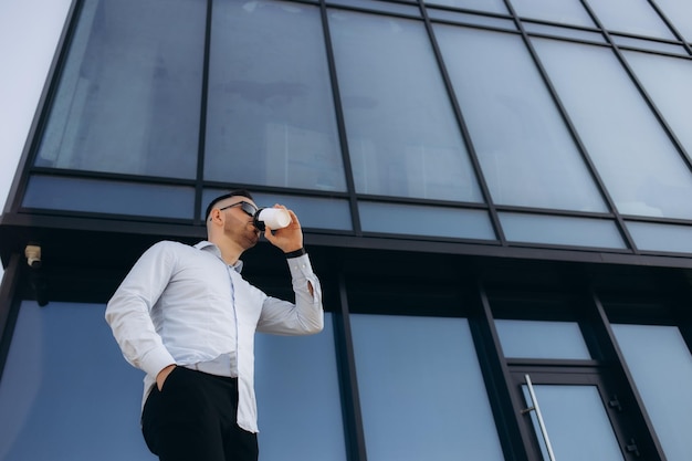 Confident male chief executive of architecture corporation going to meeting with business partners crossing street with coffee to go and chatting with secretary assistant checking preparations