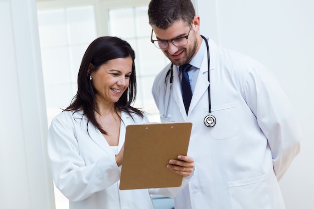 Photo confident male doctor and his nurse working in the office.