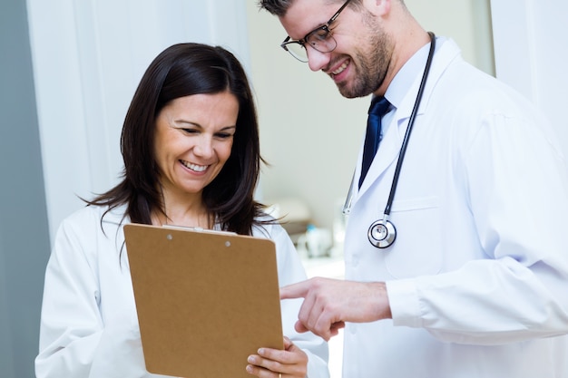 Confident male doctor and his nurse working in the office.