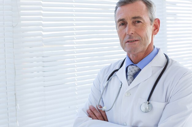 Confident male doctor looking at camera with arms crossed