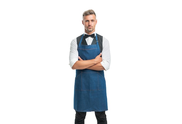 Confident man in apron and bow keeping arms crossed isolated on white, waiter.