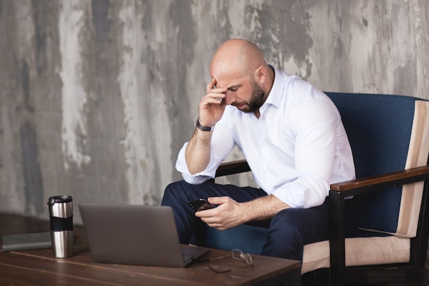 Confident man corresponds with colleagues in the messenger on the phone