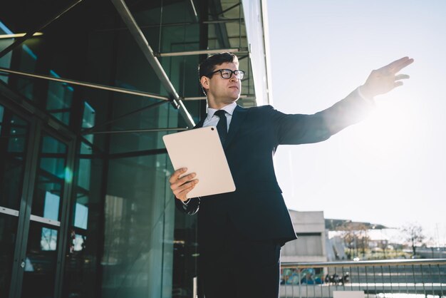 Confident man pointing away in sunlight