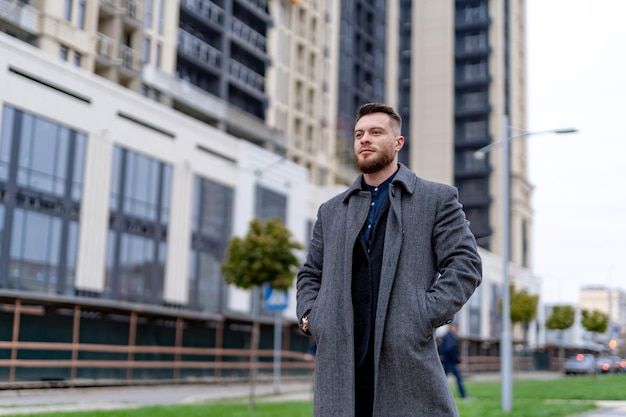 Confident man walking down the street. Young tourist looking into modern city. Successful businessman staying on the street