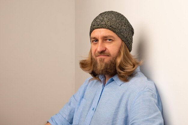 Photo confident man wearing knit hat by wall