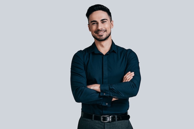 Photo confident manager. handsome young man in shirt keeping arms crossed and looking at camera