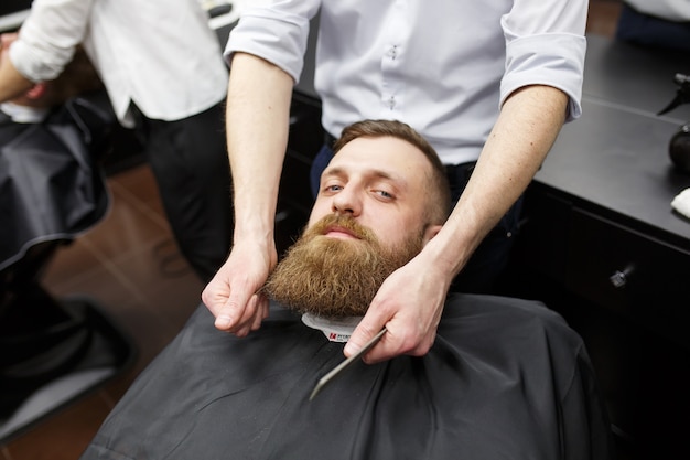 Confident mans visiting hairstylists in barber shop.