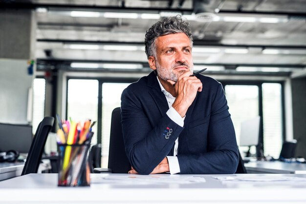 Photo confident mature businessman in office thinking