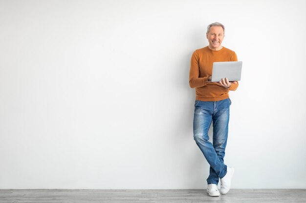 Confident mature man using laptop at home