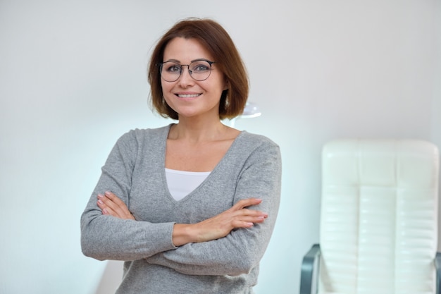 Confident mature woman owner, beauty business manager, female posing with folded arms