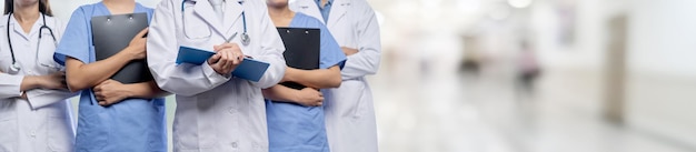 Foto team di personale medico fiducioso con medici, infermieri e professionisti specializzati nell'assistenza sanitaria persone sullo sfondo sfocato del corridoio dell'ospedale comunità medica e sanitaria in banner panoramico neoterico