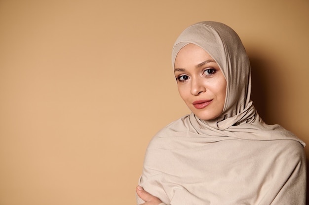 Confident portrait of a serene and beautiful Arab Muslim woman in hijab and strict conservative attire.