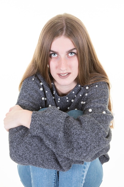 Confident portrait of young woman with arms crossed on legs isolated on white background in studio