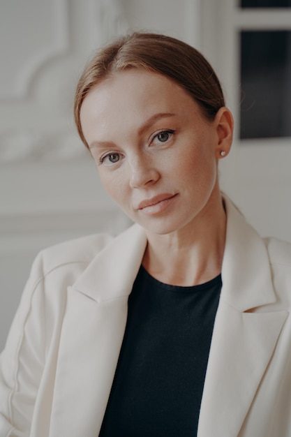 Confident pretty businesswoman in formal wear looking at camera posing for company business portrait