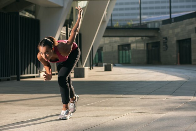 Confident professional athlete in the street standing in position for start of running. Website banner