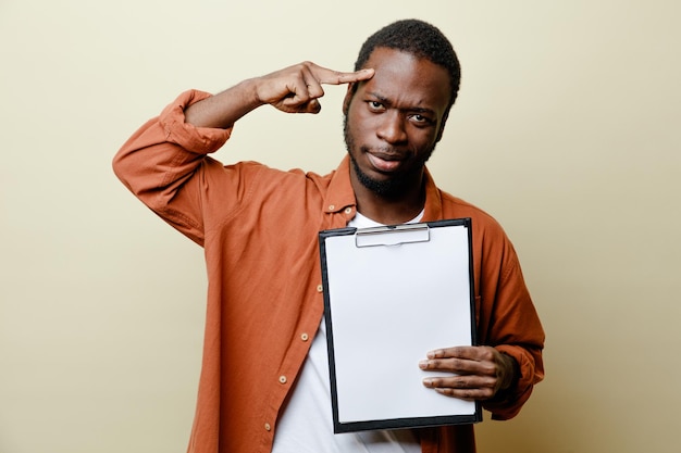 confident putting finger on head young african american male holding clipboard isolated on white background