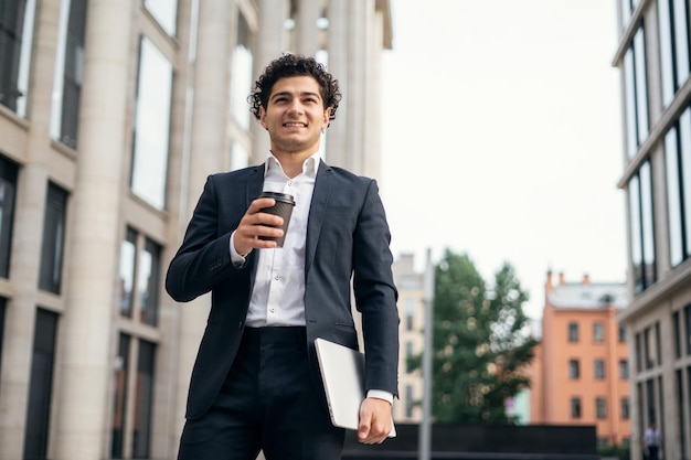 A confident satisfied male manager in an official suit goes to the office