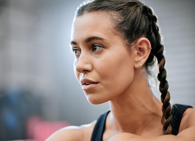Confident serious and healthy young sports woman after her exercise training and workout routine in the gym Focused determined and thinking athlete looking away to health fitness and lifestyle