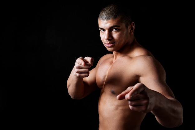 Confident shirtless african man athlete standing and pointing on you