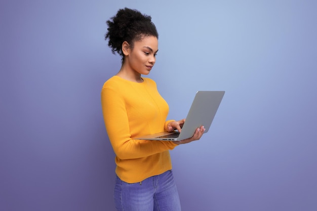 Confident smart young year old hispanic business lady with afro with a laptop in her hands