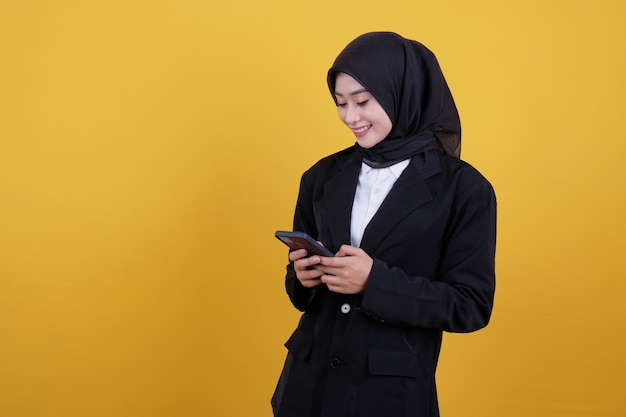 Confident smiling businesswoman holding and looking mobile phone