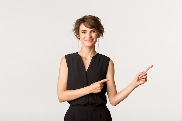 Confident smiling businesswoman pointing fingers right