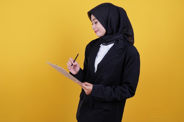 Confident smiling businesswoman writing notes on yellow