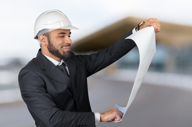 Confident smiling portrait of black architect holding plans isolated in studio