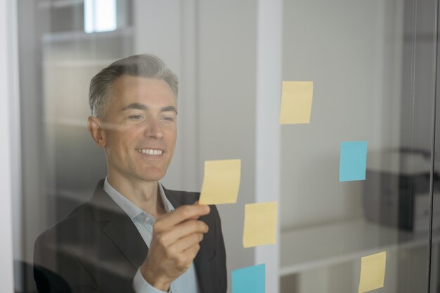 Confident smiling scrum master using sticky notes, scrum for productivity