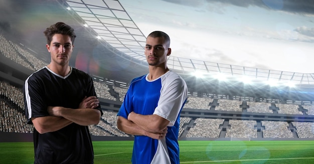 Confident soccer players standing arms crossed at stadium