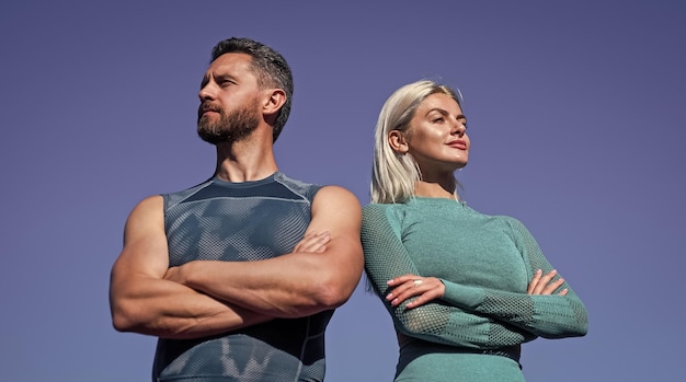 Confident sport couple muscular man and sexy woman in sportswear athlete people feel success fitness trainer and coach guy and woman relax after workout outdoor sporty fashion