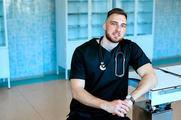 A confident strong smiling veterinarian poses in the operating room near the surgical table