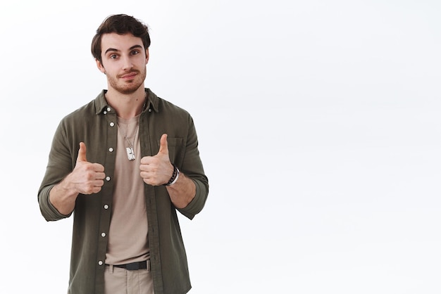 Confident stylish bearded man showing thumbsup smile and look camera pleased satisfied with team making great success awesome project recommend good company service white background