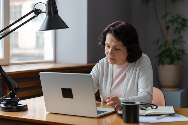 Confident stylish european middle aged senior woman using laptop at home stylish older mature s lady