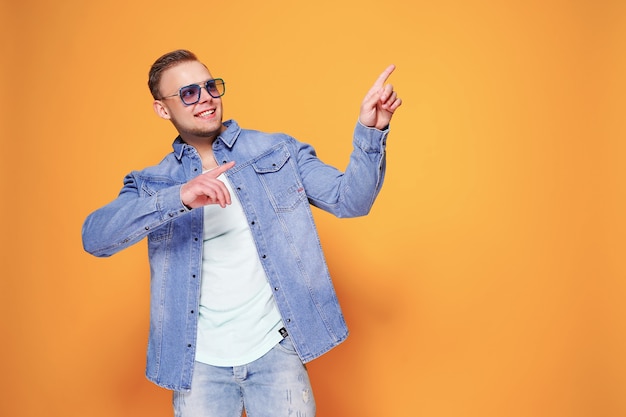 Confident stylish guy pointing at copyspace