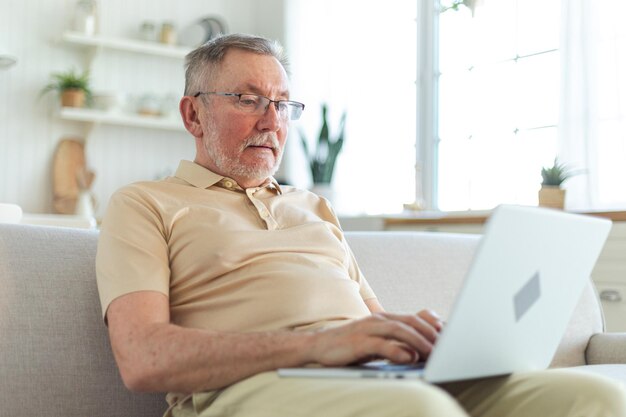 Confident stylish happy middle aged senior man using laptop at home stylish older mature s beard