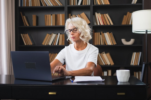 Confident stylish middle aged senior woman using laptop at workplace older mature lady businesswoman