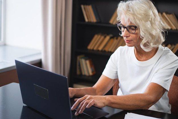 Photo confident stylish middle aged senior woman using laptop at workplace older mature lady businesswoman